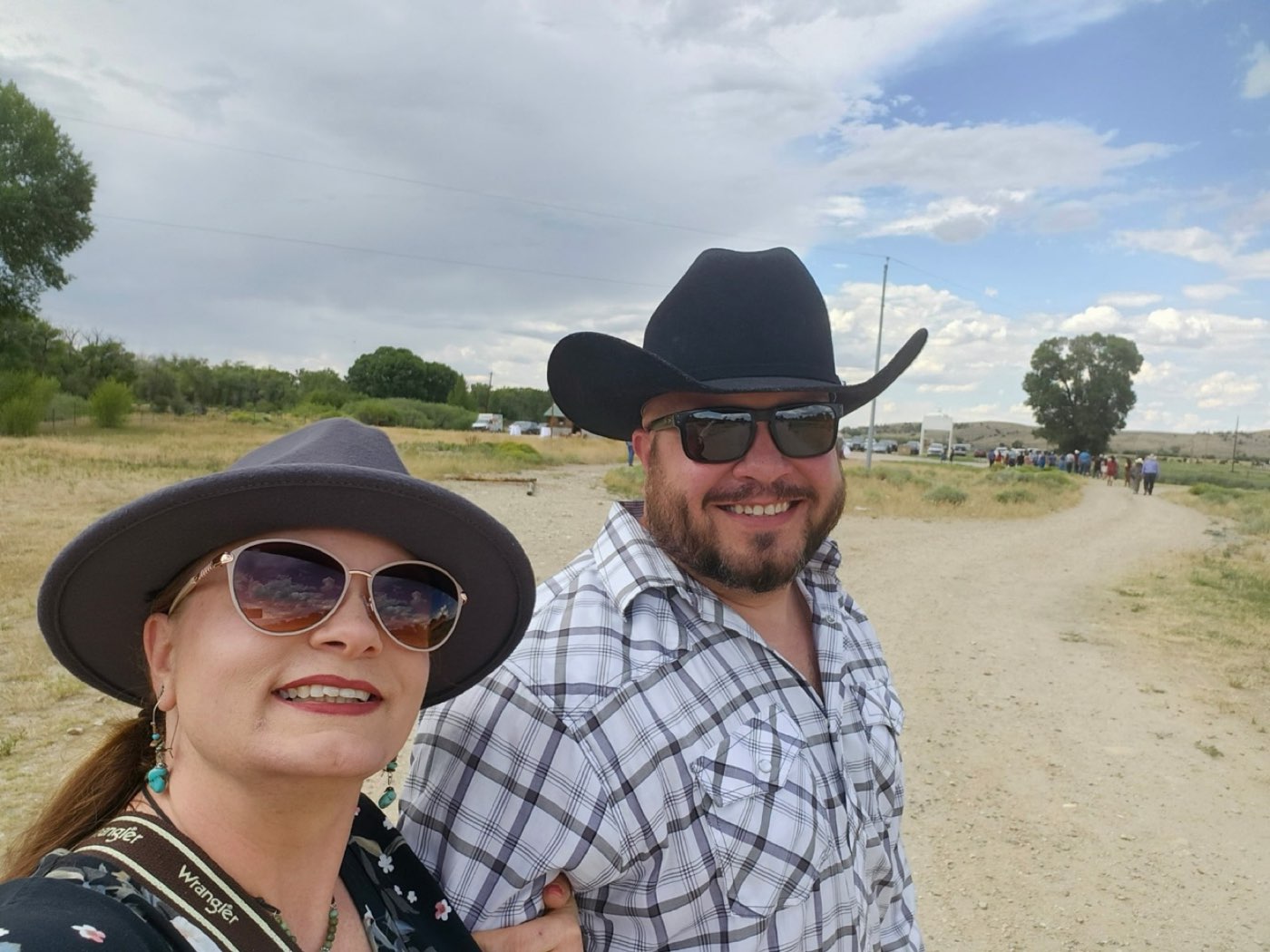 Brian Dimoff and his wife in cowboy hats at an outdoor event